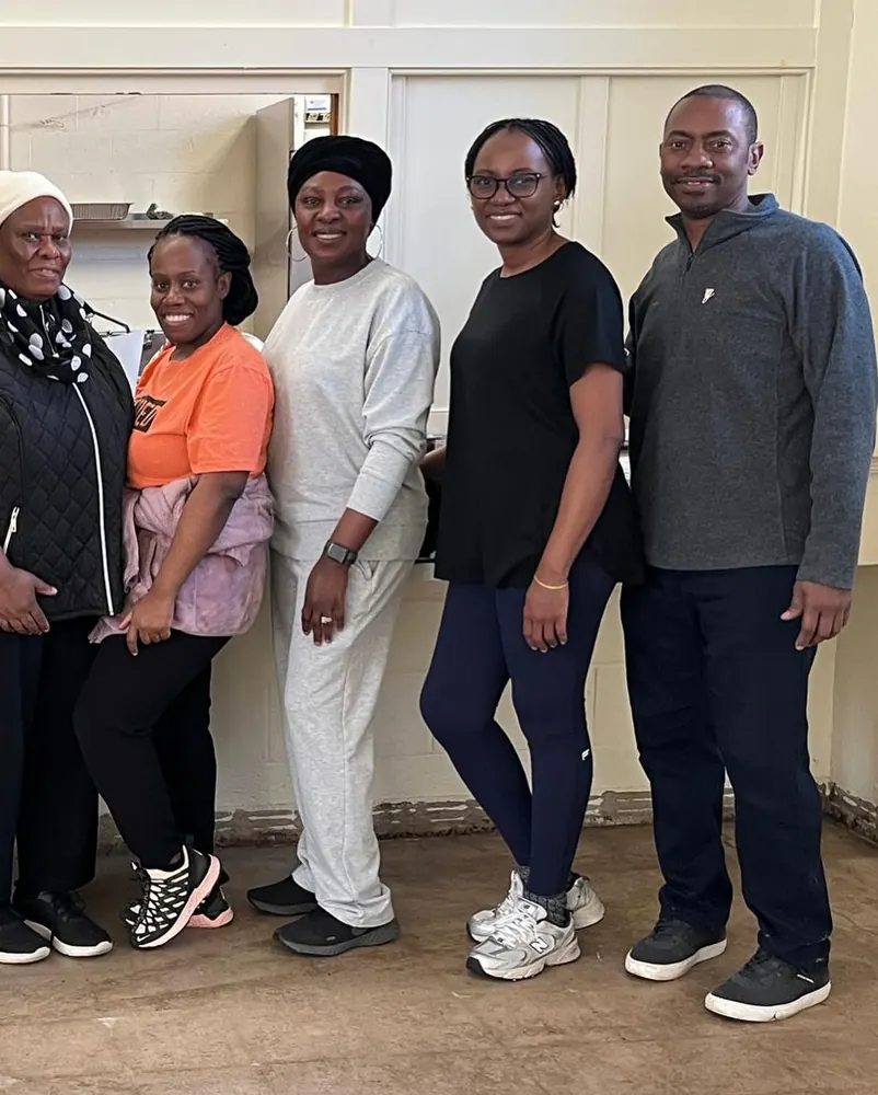 Five church members smiling together on the all-church cleaning day